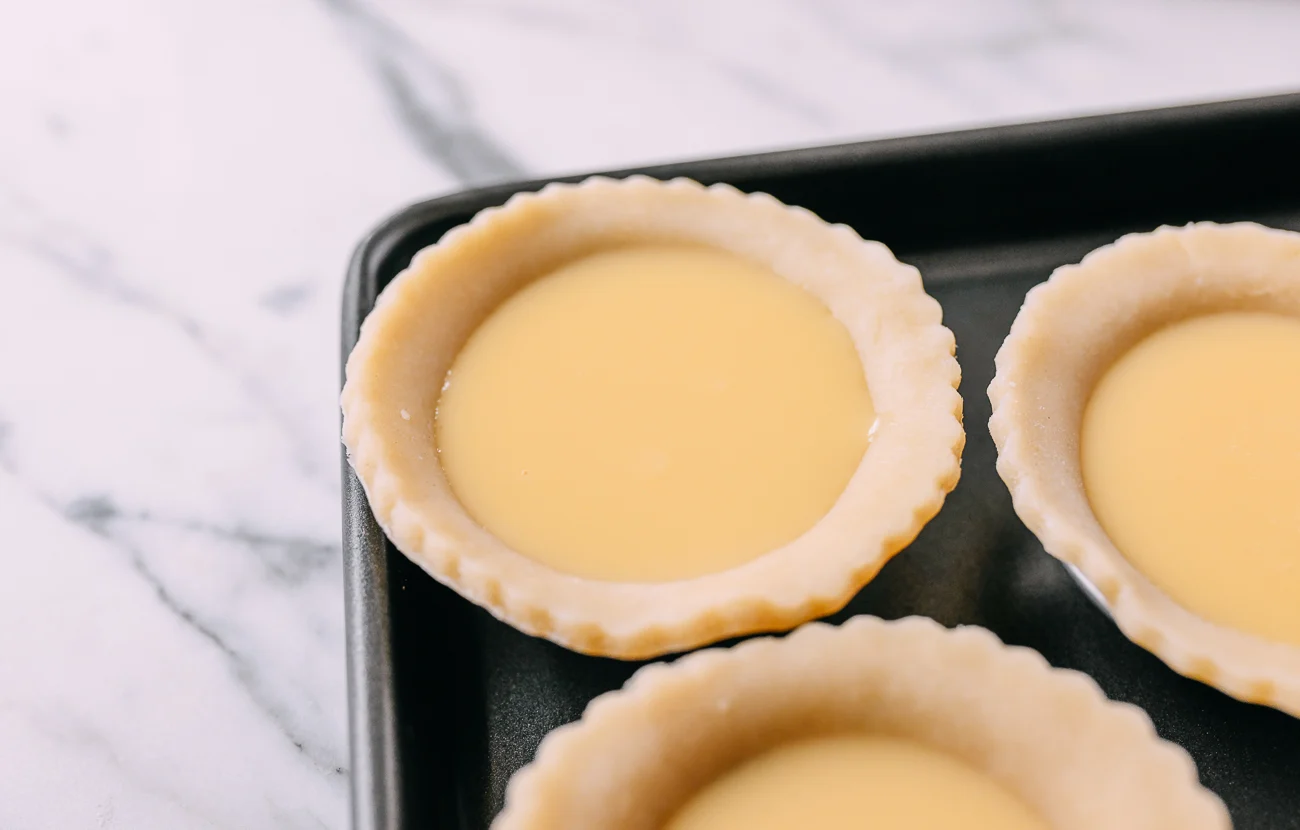Tart shells filled with custard before baking